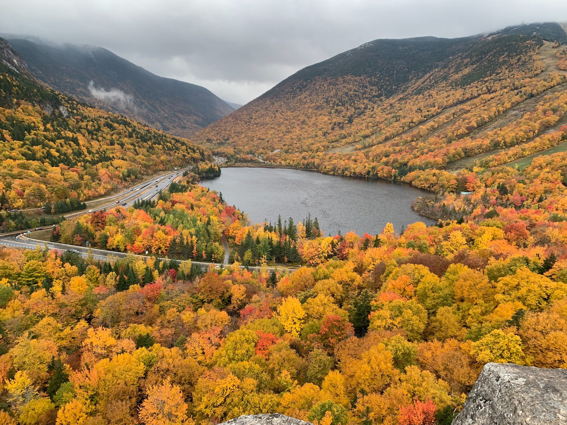 Meer, bergen en weg in New Hampshire tijdens de Indian Summer