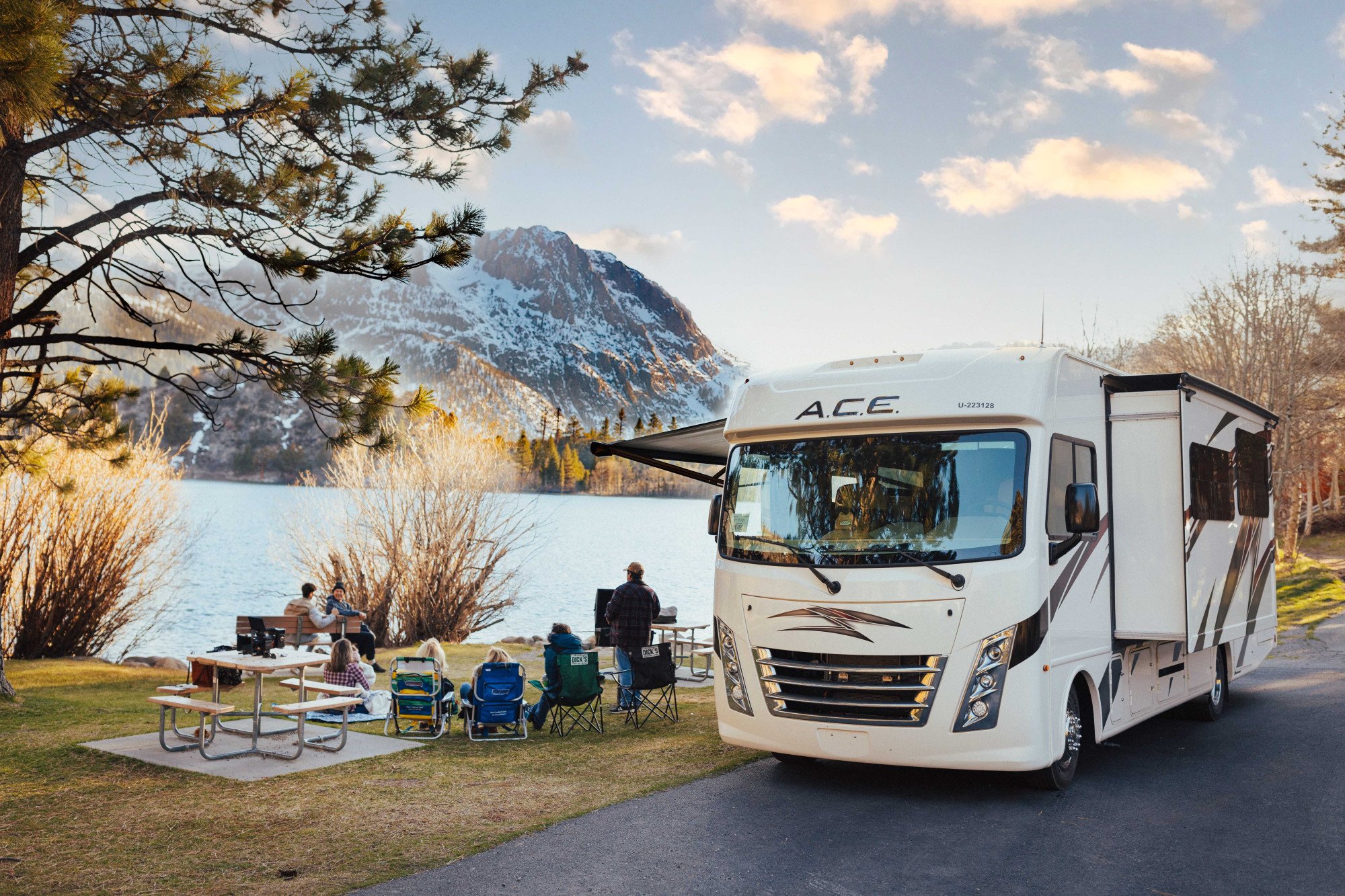 Camper Road Bear Class A slide-out 30-32 ft (type U) bij een meer met berg